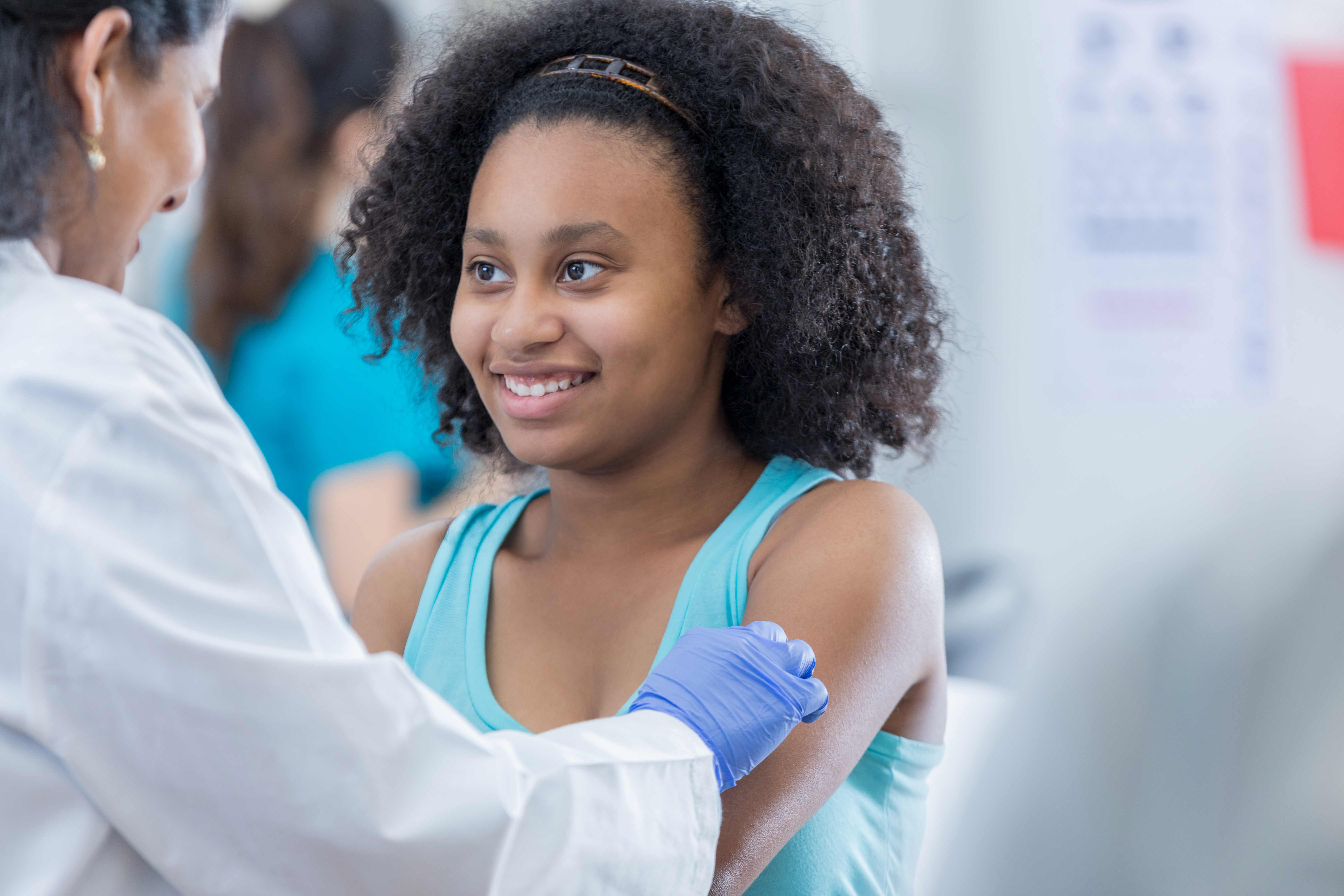 Medical worker giving a vaccination to a young girl.