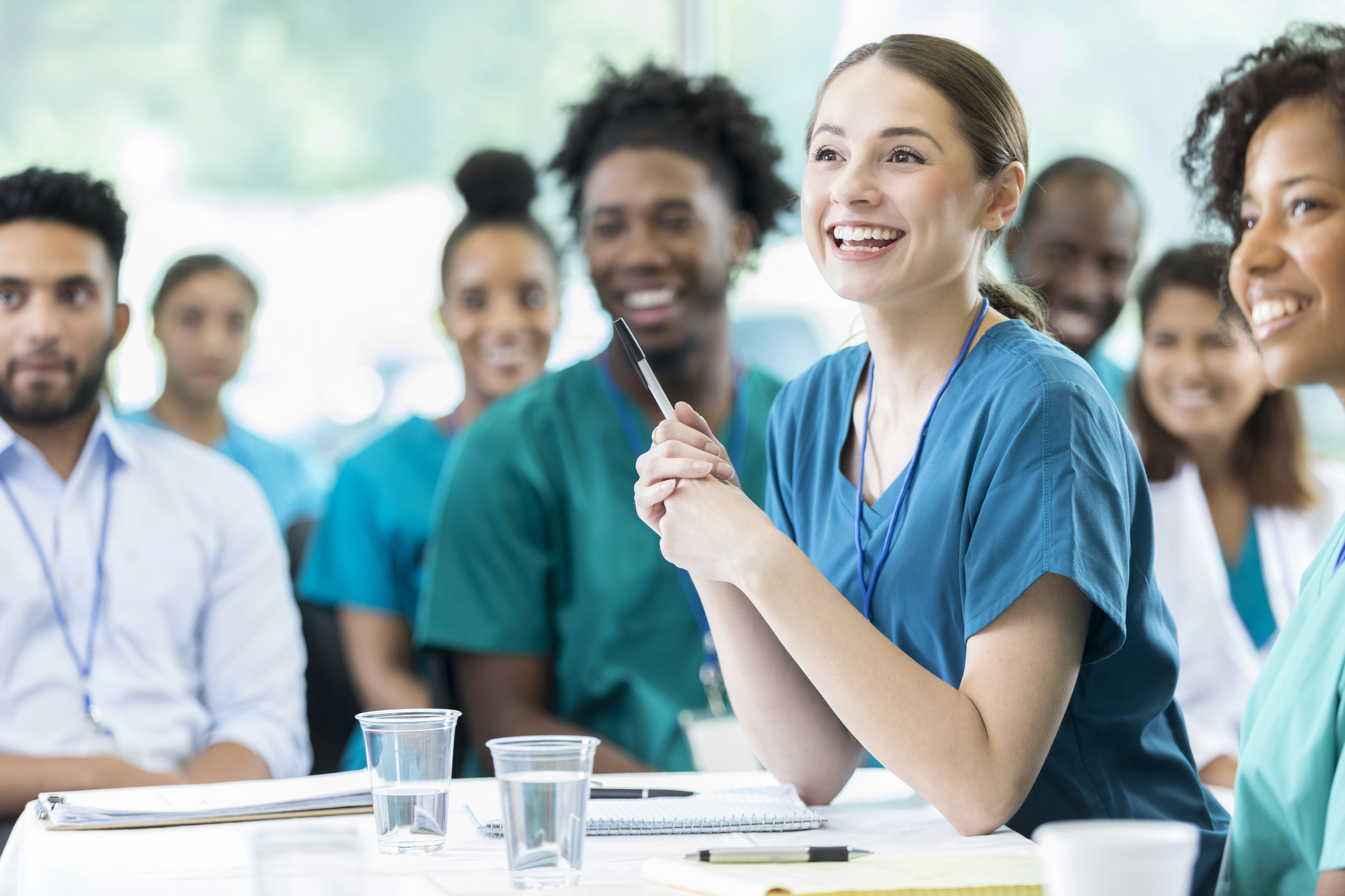 Smiling medical working sitting with a group of other medical workers